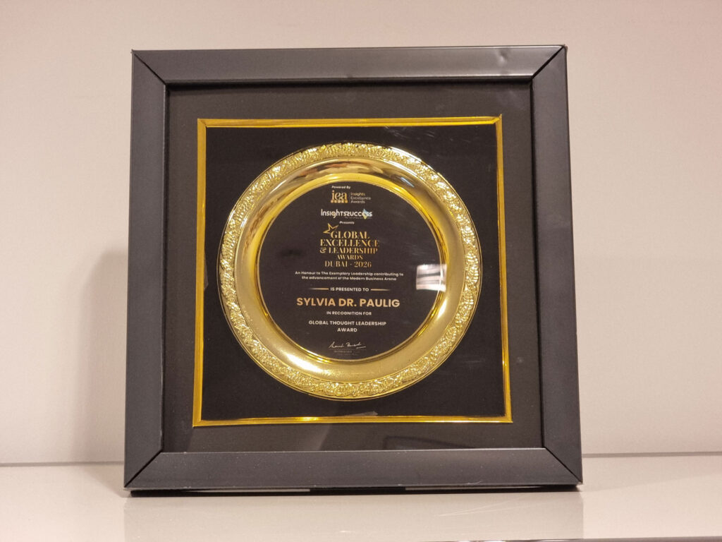 Eine goldene Auszeichnung für Sylvia Dr Paulig mit schwarzem Rahmen und glänzender Platte